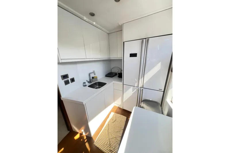  Yacht Photos Pics Modern kitchen interior on 2010 Numarine 78 yacht, featuring sleek white cabinetry and appliances.