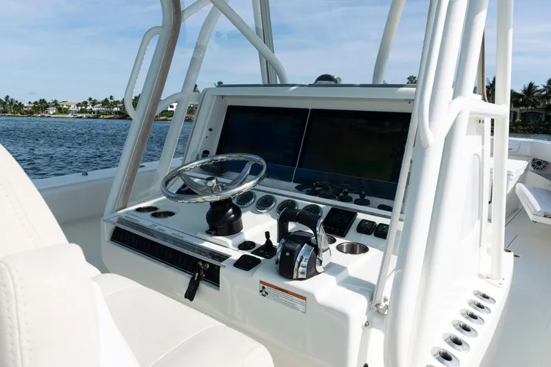  Yacht Photos Pics 2021 SeaVee 390 boat helm with steering wheel and controls, on calm water.