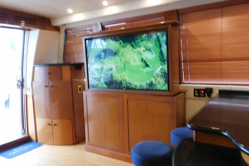 Waterdog Yacht Photos Pics Luxurious interior of 2002 Carver 570 Voyager Pilothouse with wooden cabinetry and large TV.