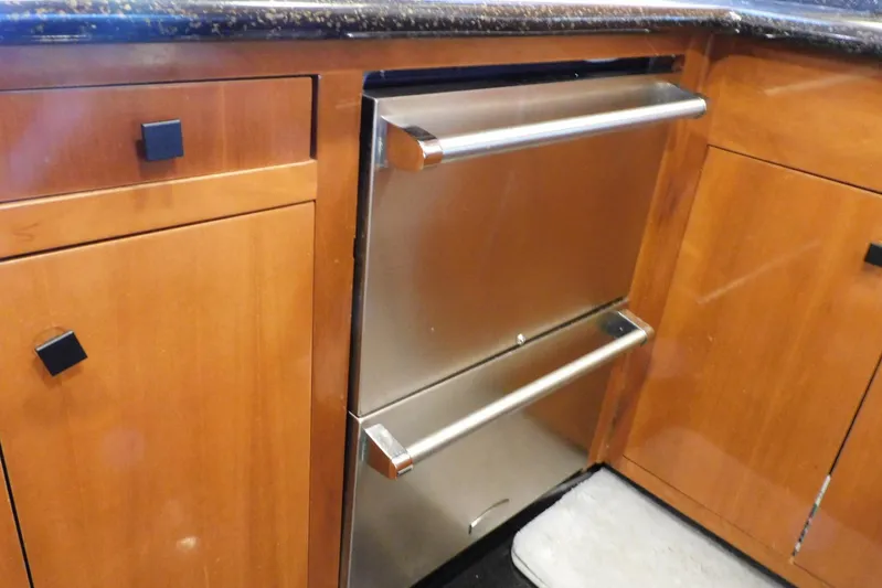 Waterdog Yacht Photos Pics Stainless steel drawer in 2002 Carver 570 Voyager Pilothouse kitchen, surrounded by wooden cabinetry.