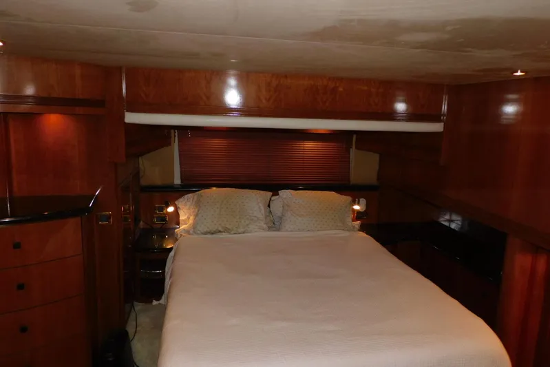 Waterdog Yacht Photos Pics Luxurious bedroom interior of 2002 Carver 570 Voyager Pilothouse yacht with wood paneling.