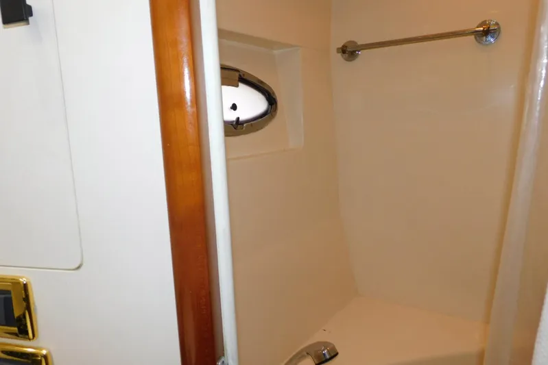 Waterdog Yacht Photos Pics Shower area inside 2002 Carver 570 Voyager Pilothouse yacht, featuring a porthole window.