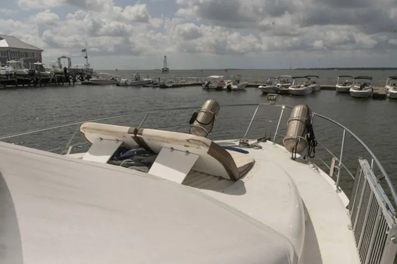 Waterdog Yacht Photos Pics 2002 Carver 570 Voyager Pilothouse yacht docked at marina under cloudy sky.