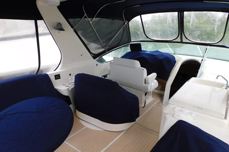 Waterdog Yacht Photos Pics Interior of 2002 Carver 570 Voyager Pilothouse with blue-covered seating and helm.