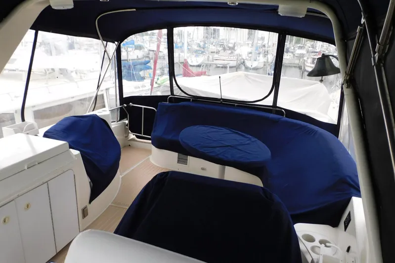 Waterdog Yacht Photos Pics Interior of 2002 Carver 570 Voyager Pilothouse with blue-covered seating and marina view.