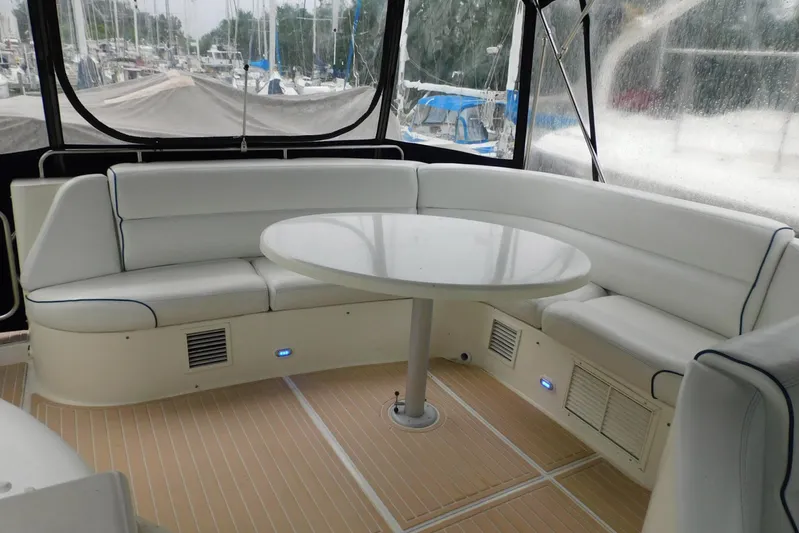Waterdog Yacht Photos Pics Luxurious seating area on 2002 Carver 570 Voyager Pilothouse yacht with round table.