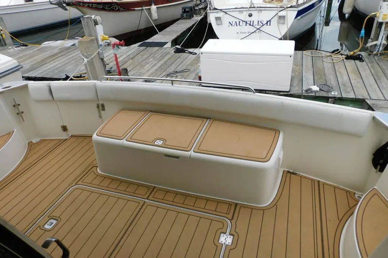 Waterdog Yacht Photos Pics 2002 Carver 570 Voyager Pilothouse boat deck at marina, featuring cushioned seating and storage.