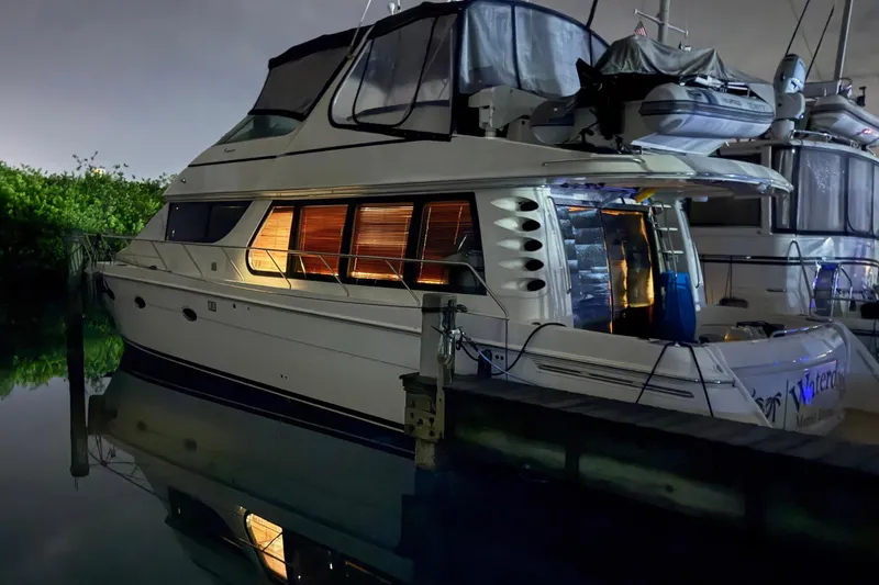 Waterdog Yacht Photos Pics 2002 Carver 570 Voyager Pilothouse yacht docked at night, illuminated interior.