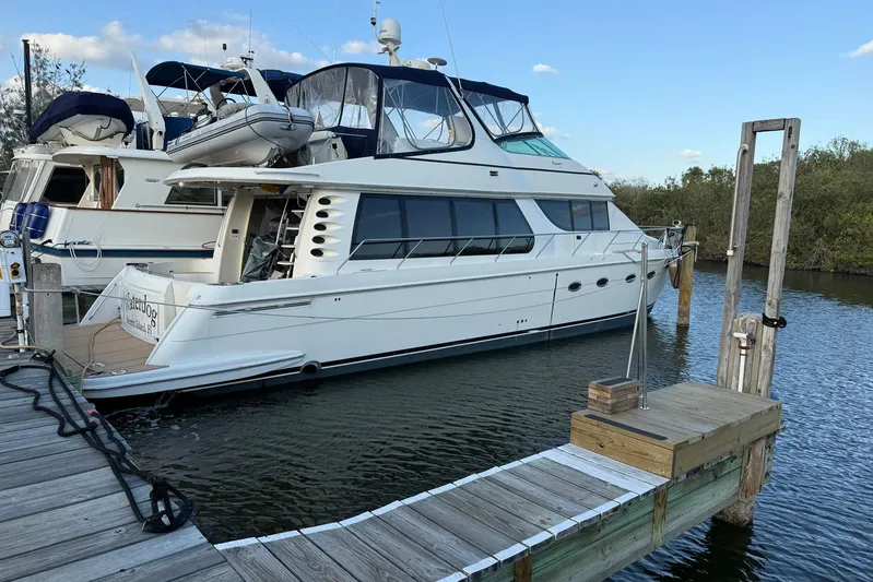 Waterdog Yacht Photos Pics 2002 Carver 570 Voyager Pilothouse yacht docked at marina, side view.