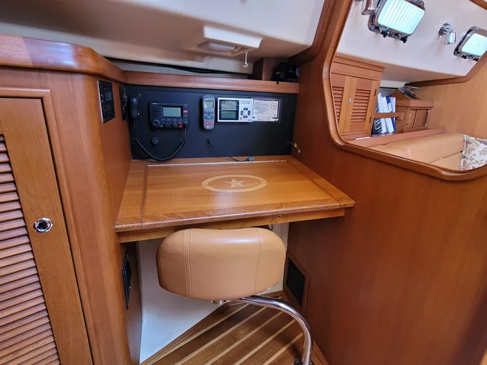 Mango Lll Yacht Photos Pics Navigation station in 2006 Island Packet 370 sailboat with wooden desk and communication equipment.