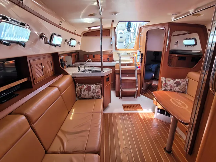 Mango Lll Yacht Photos Pics Interior of 2006 Island Packet 370 sailboat with cozy seating and wooden finishes.