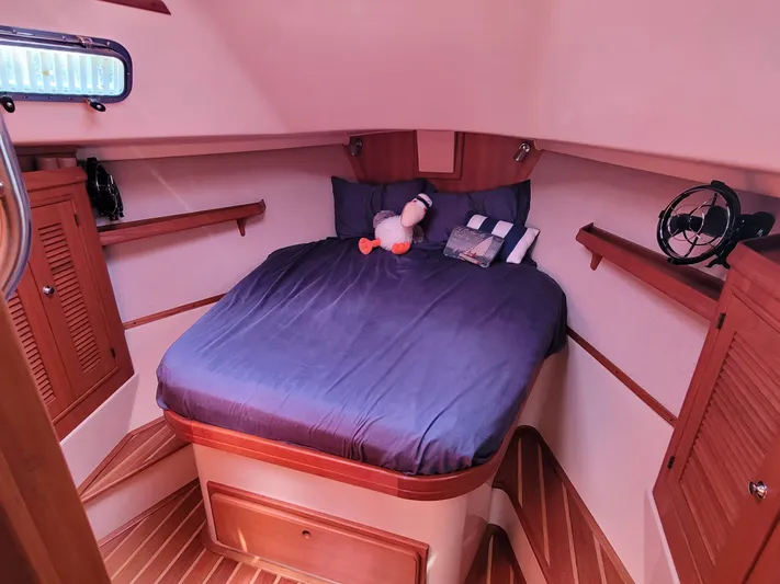 Mango Lll Yacht Photos Pics Cozy cabin interior of 2006 Island Packet 370 sailboat with blue bedding and wooden accents.