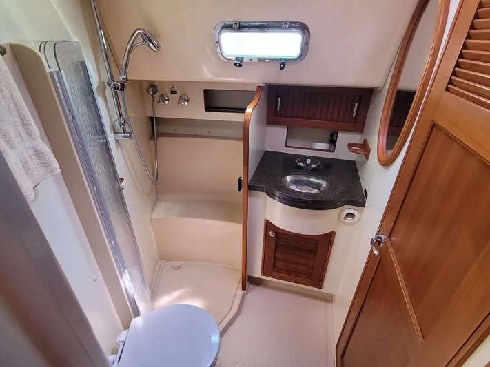 Mango Lll Yacht Photos Pics Bathroom interior of 2006 Island Packet 370 yacht with shower, sink, and wooden cabinetry.