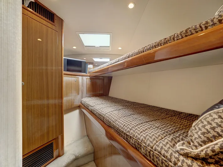  Yacht Photos Pics 2007 Viking Convertible yacht interior with mezzanine, featuring cozy bunk beds and wooden cabinetry.