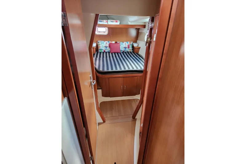 Leopard 46 Yacht Photos Pics Cozy cabin interior of 2009 Leopard 46 yacht with striped bedding and wooden finish.