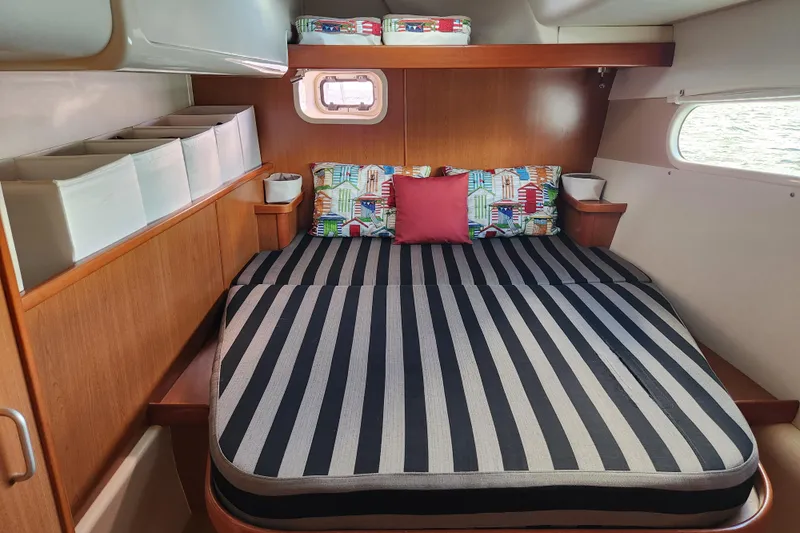 Leopard 46 Yacht Photos Pics Cozy cabin interior of 2009 Leopard 46 yacht with striped bedding and colorful pillows.