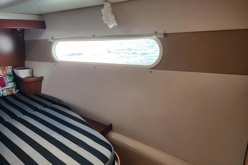 Leopard 46 Yacht Photos Pics Interior cabin of 2009 Leopard 46 yacht with striped bedding and ocean view window.