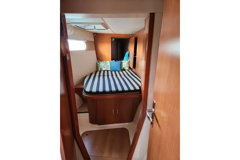 Leopard 46 Yacht Photos Pics Cozy cabin interior of 2009 Leopard 46 yacht with striped bedding and wooden finish.