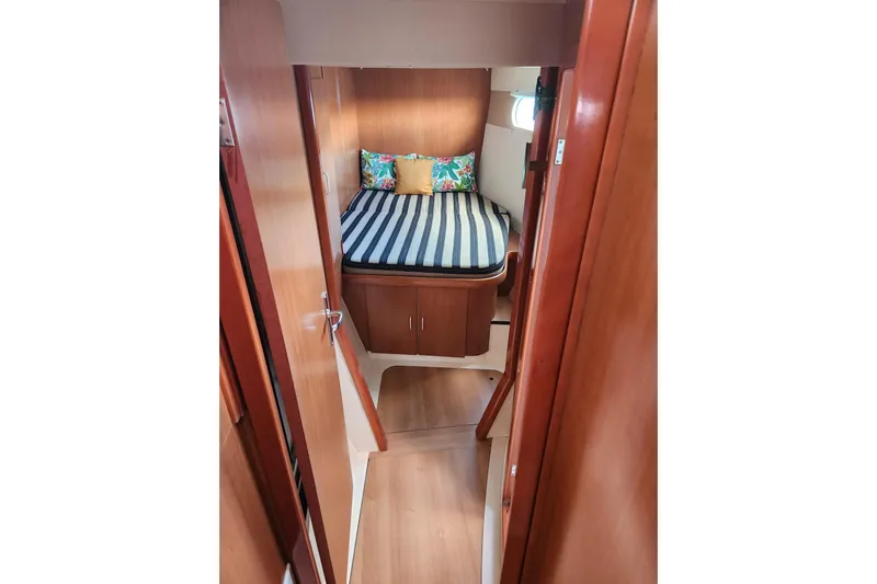 Leopard 46 Yacht Photos Pics Interior cabin of 2009 Leopard 46 yacht with striped bedding and wooden finish.