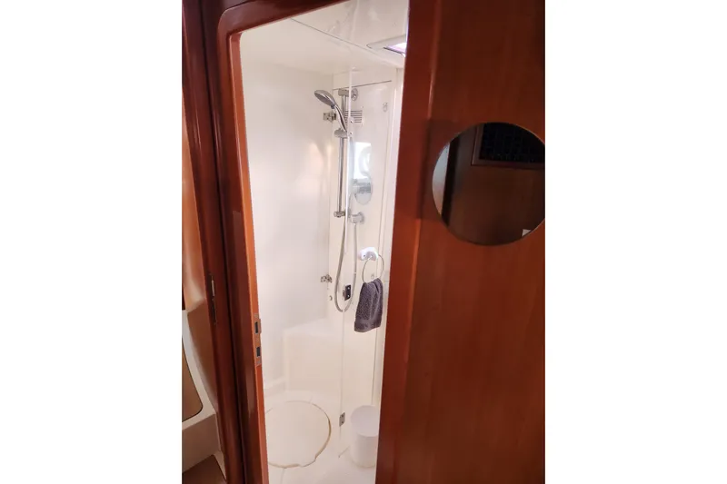 Leopard 46 Yacht Photos Pics Shower area in 2009 Leopard 46 yacht with wooden door and modern fixtures.