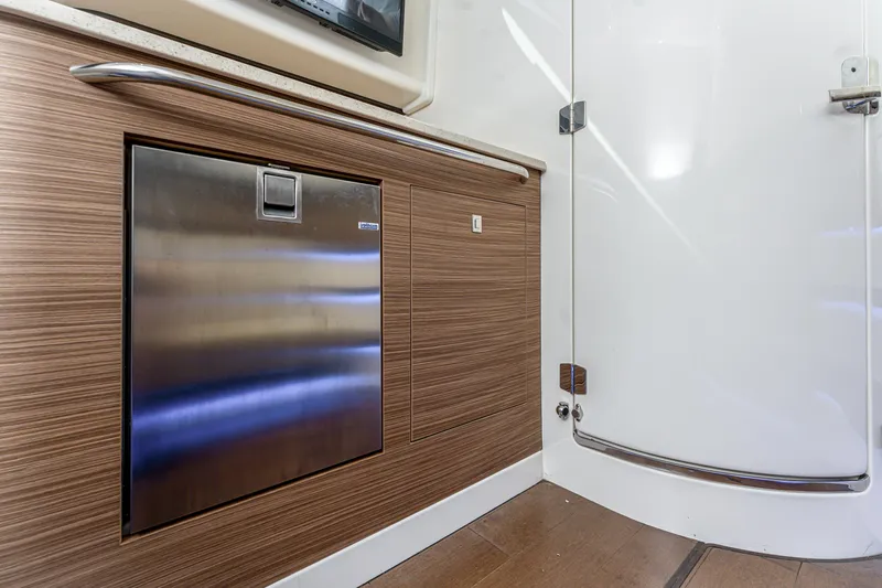 Jet Lag Yacht Photos Pics 2019 Boston Whaler 420 Outrage interior with sleek wood paneling and stainless steel appliance.