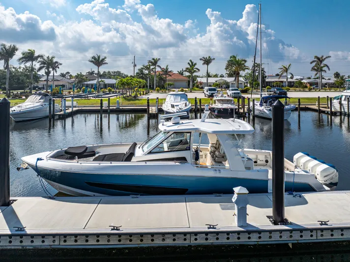 Jet Lag Yacht Photos Pics 2019 Boston Whaler 420 Outrage docked at a sunny marina with palm trees.