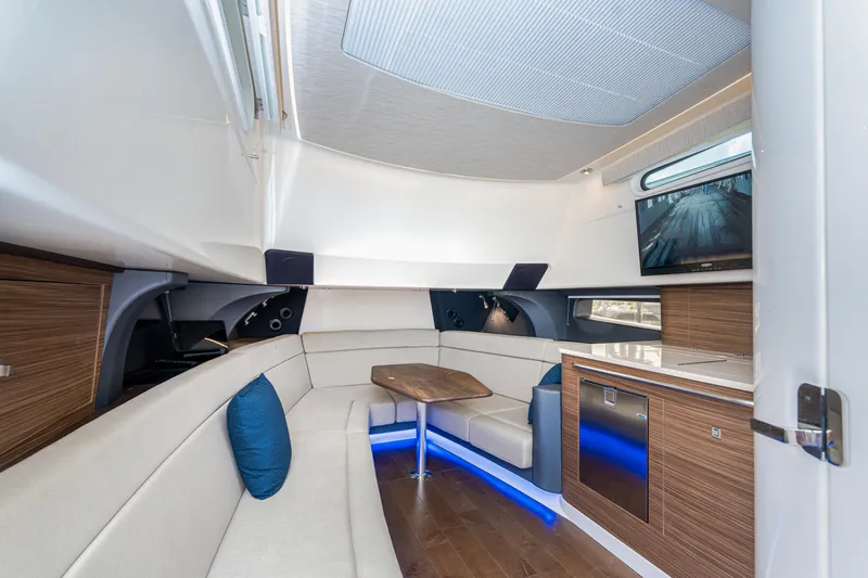 Jet Lag Yacht Photos Pics 2019 Boston Whaler 420 Outrage interior with modern seating, wood accents, and a mounted TV.