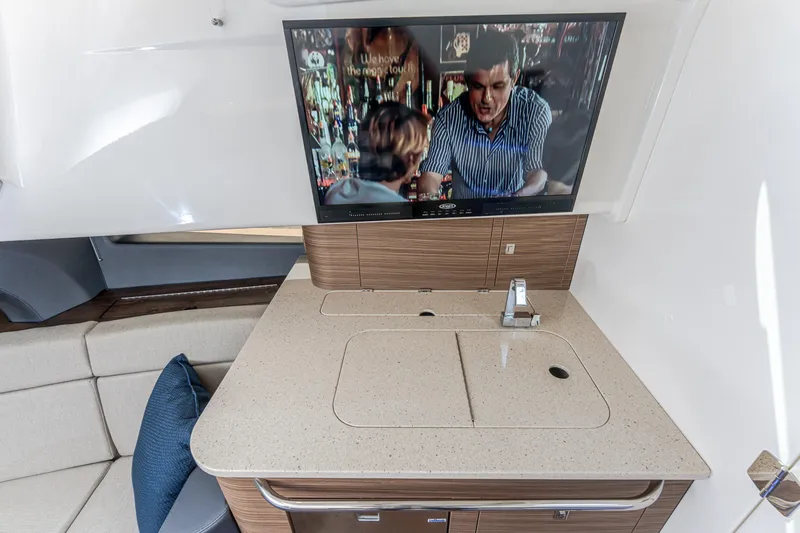 Jet Lag Yacht Photos Pics 2019 Boston Whaler 420 Outrage interior with TV and modern kitchenette setup.