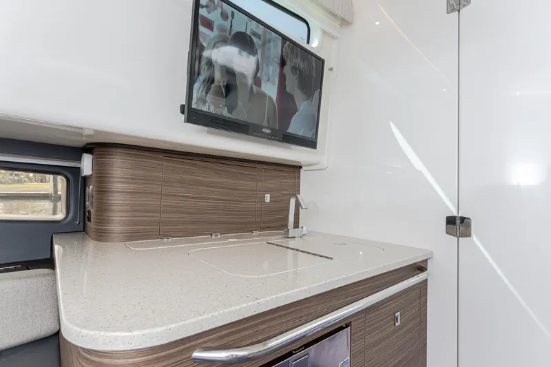 Jet Lag Yacht Photos Pics 2019 Boston Whaler 420 Outrage interior with modern kitchenette and mounted TV.