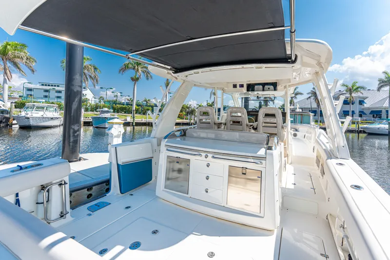 Jet Lag Yacht Photos Pics 2019 Boston Whaler 420 Outrage boat interior with seating and storage, docked in a sunny marina.