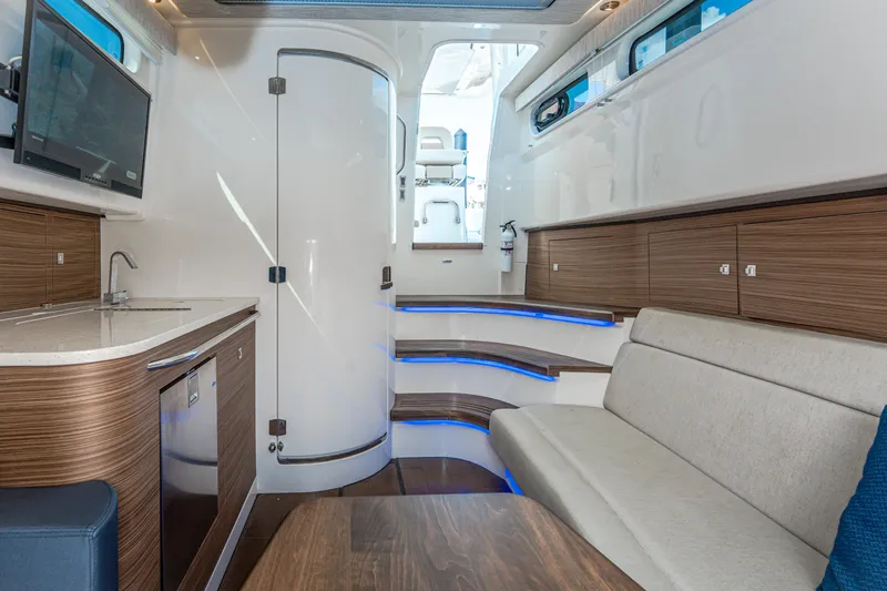 Jet Lag Yacht Photos Pics 2019 Boston Whaler 420 Outrage interior with modern seating, kitchenette, and ambient lighting.
