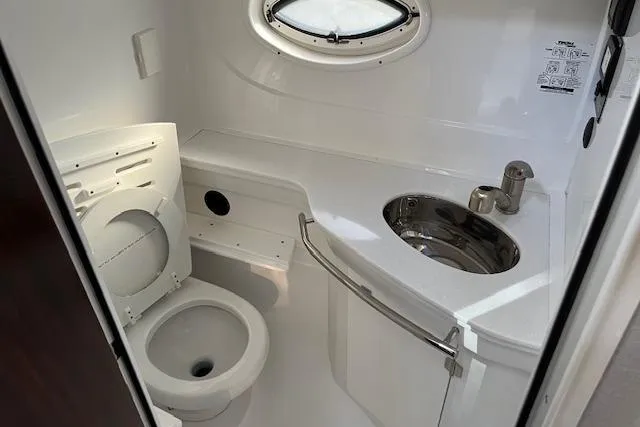  Yacht Photos Pics Compact bathroom in 2019 Monterey 355 Sport Yacht with toilet, sink, and porthole window.