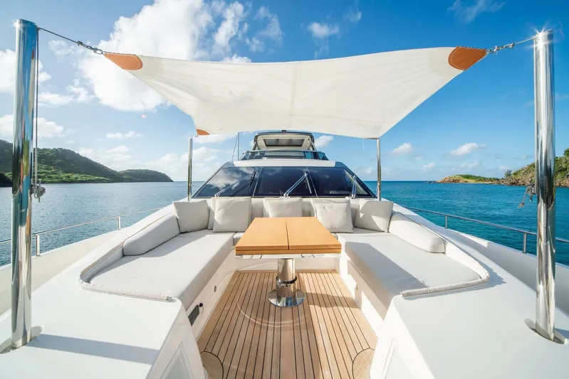 Squalo Yacht Photos Pics Sanlorenzo SL86 2018 yacht deck with seating, table, and sunshade, overlooking serene blue waters.