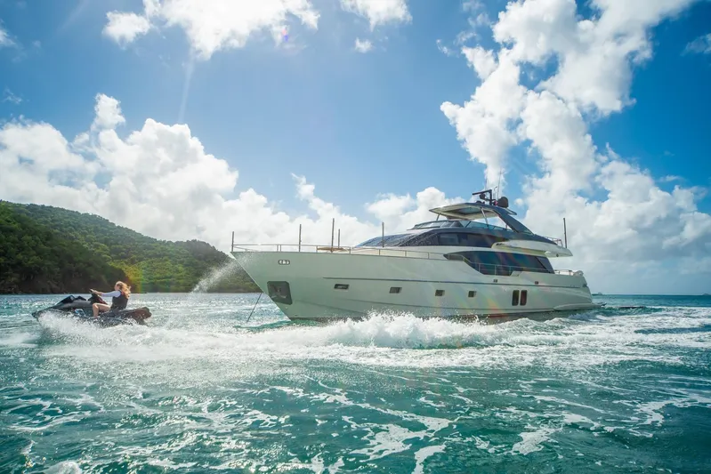 Squalo Yacht Photos Pics 2018 Sanlorenzo SL86 yacht cruising with jet ski nearby, under a bright blue sky.