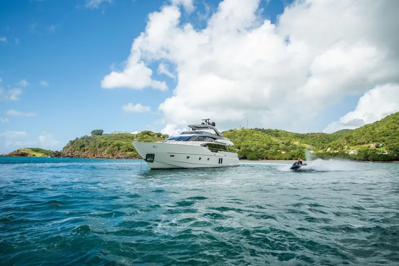 Squalo Yacht Photos Pics Sanlorenzo SL86 yacht cruising near lush island, 2018 model, with jet ski nearby.