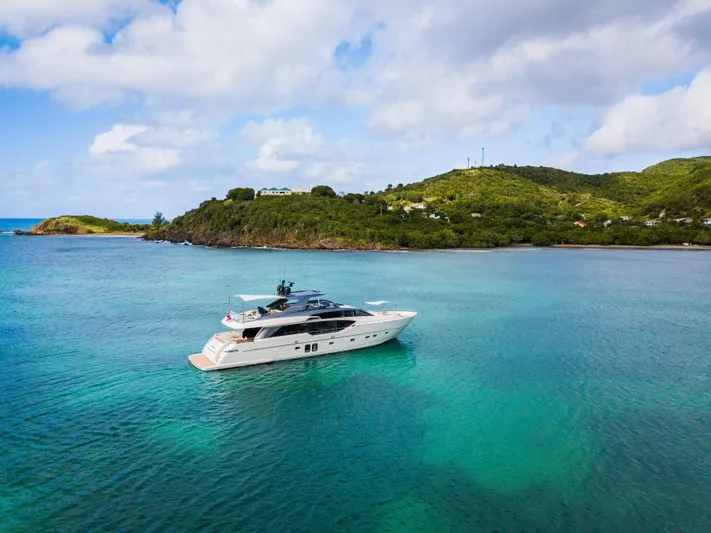 Squalo Yacht Photos Pics Sanlorenzo SL86 yacht cruising in turquoise waters near lush green island, 2018 model.
