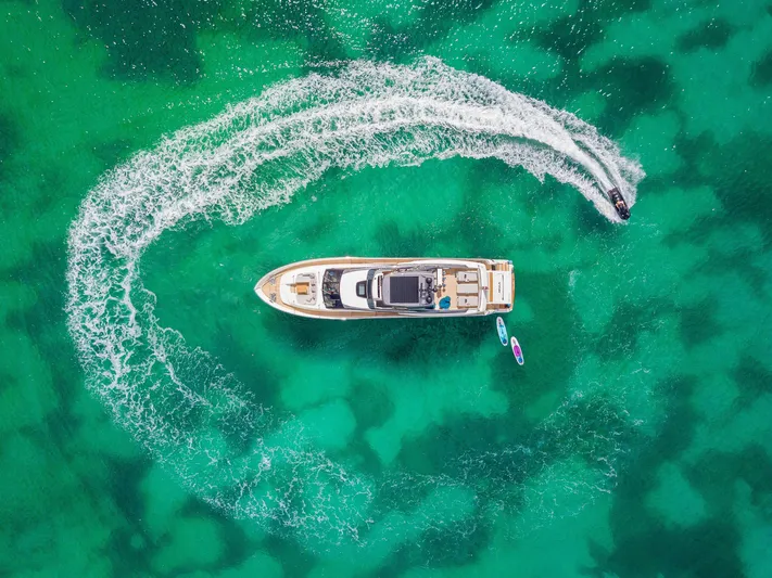 Squalo Yacht Photos Pics Aerial view of 2018 Sanlorenzo SL86 yacht in turquoise water with jet ski circling.
