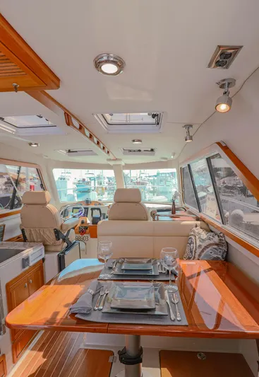 Arrow II Yacht Photos Pics Luxurious interior of 2019 Aspen C107 yacht with elegant dining setup and panoramic windows.