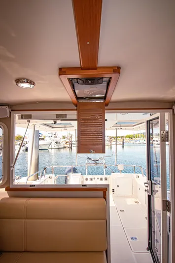 Arrow II Yacht Photos Pics Interior view of 2019 Aspen C107 boat, showcasing seating and marina backdrop.