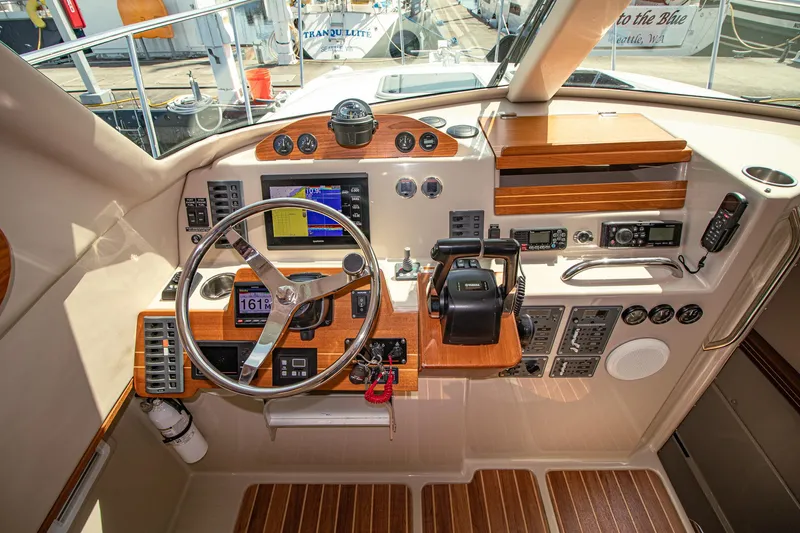 Arrow II Yacht Photos Pics Cockpit of 2019 Aspen C107 boat with steering wheel, navigation controls, and wooden accents.
