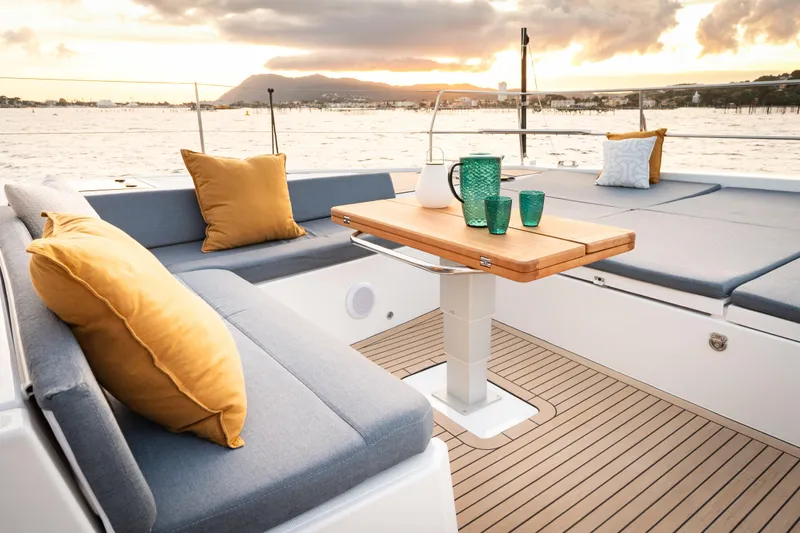  Yacht Photos Pics Luxurious Bali 5.2 yacht deck with cushions and table, 2026 model, at sunset.