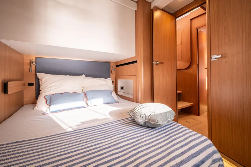  Yacht Photos Pics Luxurious cabin interior of 2026 Bali 5.2 yacht with cozy bedding and wooden finishes.