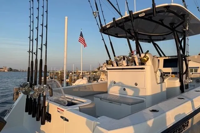  Yacht Photos Pics 2023 Contender 32 ST fishing boat docked with rods and American flag.
