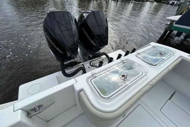  Yacht Photos Pics 2023 Contender 32 ST boat with dual Mercury outboard engines on a calm waterway.