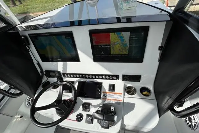  Yacht Photos Pics 2023 Contender 32 ST boat dashboard with dual navigation screens and steering wheel.