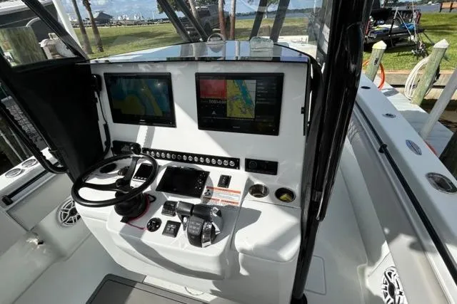  Yacht Photos Pics 2023 Contender 32 ST boat cockpit with dual navigation screens and control panel.