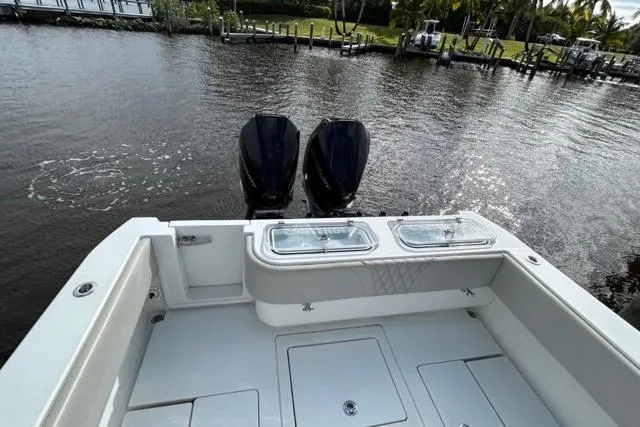  Yacht Photos Pics 2023 Contender 32 ST boat with dual outboard motors on a calm river.