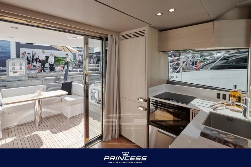  Yacht Photos Pics Luxurious interior of 2023 Princess F50 yacht with modern kitchen and outdoor seating area.