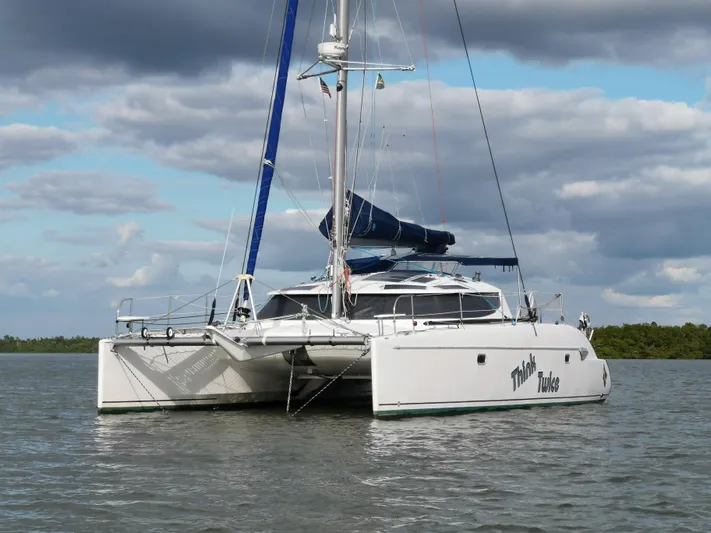 Think Twice Yacht Photos Pics 2005 Fountaine Pajot Lavezzi Maestro catamaran on calm water under cloudy sky.