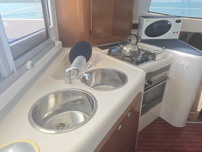 Think Twice Yacht Photos Pics 2005 Fountaine Pajot Lavezzi Maestro kitchen with dual sinks, stove, and microwave.
